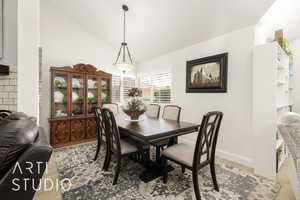 Dining area with high vaulted ceiling and baseboards