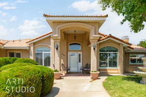 Property entrance featuring a tiled roof, stucco siding, and a chimney