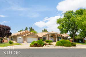 Mediterranean / spanish-style house with driveway, a garage, stucco siding, and a tiled roof
