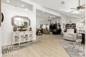 Living area with ceiling fan, wood finished floors, recessed lighting, and vaulted ceiling