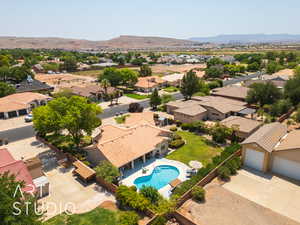 Aerial perspective of suburban area featuring a mountain backdrop and a pool