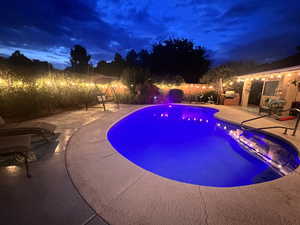 Pool at night featuring a patio