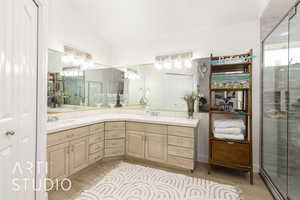 Bathroom with lofted ceiling, wood finished floors, double vanity, and a shower stall
