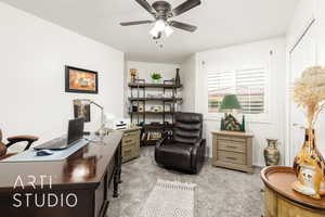 Office area with light colored carpet and a ceiling fan