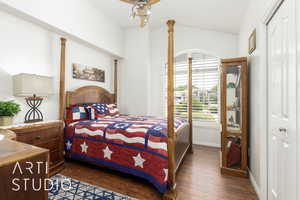 Bedroom with lofted ceiling and dark wood-type flooring