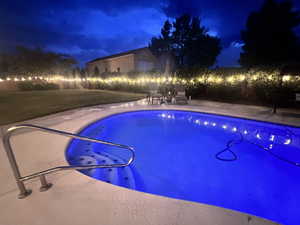 Pool at twilight featuring a patio