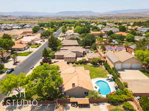 Aerial perspective of suburban area with a pool and a mountainous background