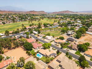 Aerial view of residential area with a mountainous background and a local golf course
