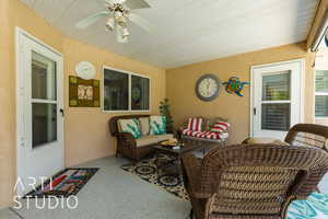Sunroom featuring a ceiling fan and an outdoor living space