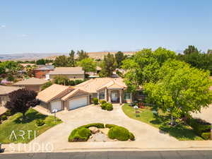 Mediterranean / spanish house with curved driveway, a garage, stucco siding, a residential view, and a tiled roof