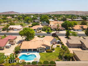 Aerial perspective of suburban area with a pool and a mountainous background