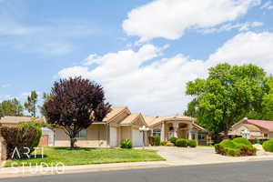 Mediterranean / spanish house featuring a garage, driveway, stucco siding, and a front yard