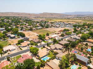 Aerial perspective of suburban area featuring a mountain backdrop and a pool