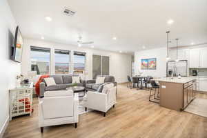 Living room featuring light wood finished floors, recessed lighting, and a ceiling fan