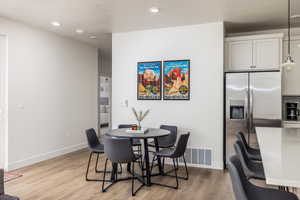 Dining space with light wood-type flooring and recessed lighting