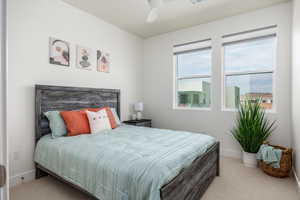 Carpeted bedroom featuring baseboards and ceiling fan