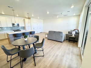 Dining area with light wood-style floors, recessed lighting, and a ceiling fan