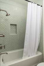 Bathroom featuring shower / tub combo with curtain and toilet