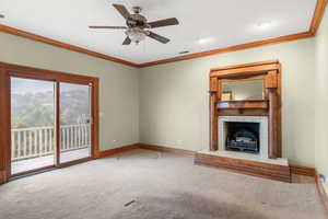 Unfurnished living room with crown molding, carpet floors, a tile fireplace, a ceiling fan, and recessed lighting