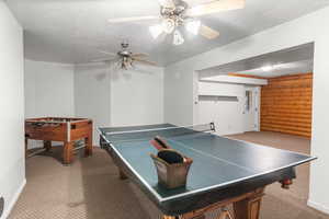 Rec room with carpet, a textured ceiling, and ceiling fan