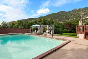 View of swimming pool featuring a mountain view and a patio