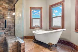 Full bathroom with a freestanding bath, a shower stall, and tile patterned flooring