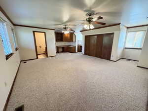 Unfurnished living room with light carpet and ornamental molding