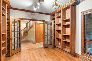 Unfurnished office with crown molding, light wood finished floors, and track lighting