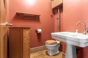 Bathroom with light wood-style flooring and a textured wall