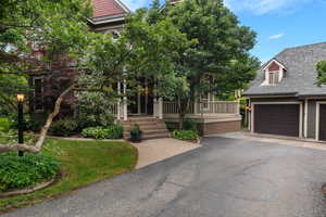 View of front of home featuring a porch, asphalt driveway, and a garage