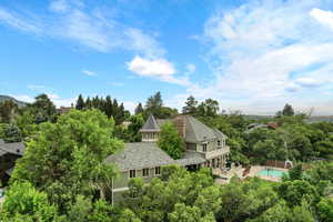 View from above of property featuring a pool and a tree filled landscape