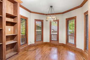 Unfurnished dining area with crown molding and light wood finished floors