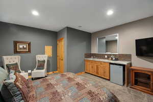 Kitchen featuring light carpet, fridge, decorative backsplash, and recessed lighting