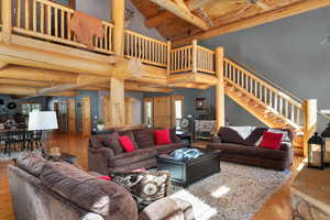Living area featuring wood finished floors, stairs, high vaulted ceiling, and a wood ceiling with exposed beams