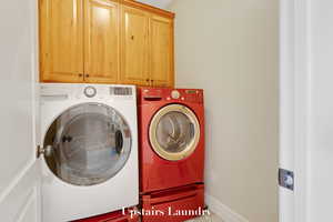 Washroom with washing machine and clothes dryer and cabinet space