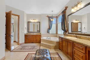 Full bath featuring two vanities and a bath