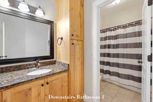 Full bathroom featuring vanity, tile patterned floors, and a shower with curtain