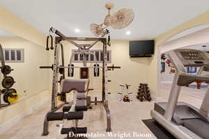 Exercise room with arched walkways, recessed lighting, and carpet