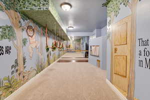 Hall with carpet and wallpapered walls