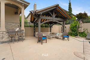 Fenced backyard featuring an outdoor hangout area, a gazebo, and a patio area