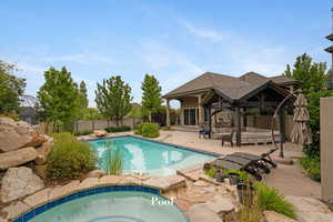 View of pool with an outdoor living space, a gazebo, an in-ground hot tub, a patio, and a fenced backyard