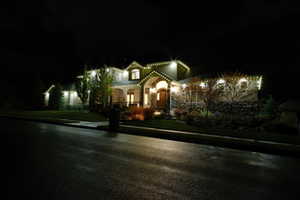 View of front facade featuring a yard, a porch, and stone siding