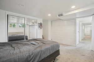 Bedroom with light carpet, a closet, and recessed lighting