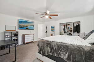 Carpeted bedroom with a closet and ceiling fan