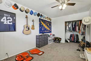 Carpeted bedroom featuring a closet, ceiling fan, and a textured ceiling