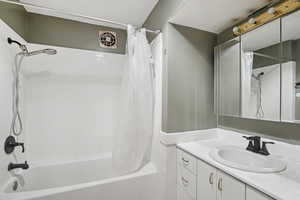 Full bathroom with shower / tub combo with curtain and vanity