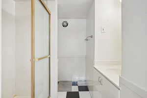 Bathroom featuring vanity, a shower stall, tile patterned floors, and a textured ceiling