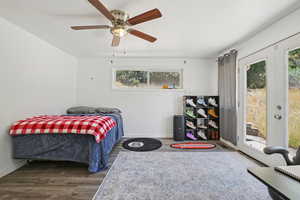 Bedroom featuring access to outside, wood finished floors, and ceiling fan