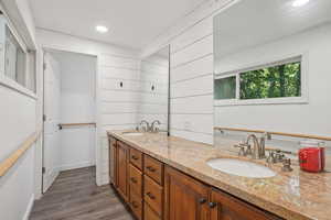 Bathroom with double vanity, wood finished floors, and recessed lighting