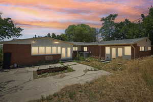 Back of house at dusk featuring french doors, brick siding, and board and batten siding